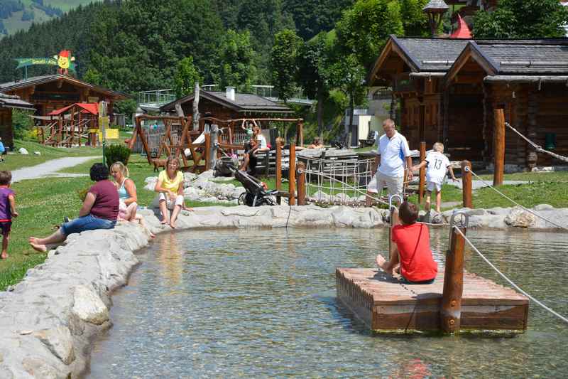 Abenteuerspielplatz in den Bergen mit Floß und Wasserspielplatz