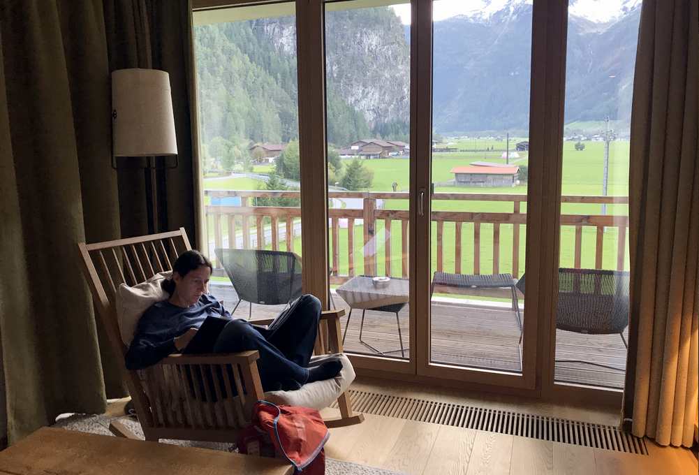 Das gemütliche Wohnzimmer mit Schaukelstuhl und Ausblick auf die Alpen