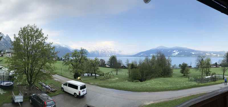 Am nächsten Morgen: Der Blick von der Ferienwohnung über den Attersee mit blauem Himmel und Schnee auf den Bergen