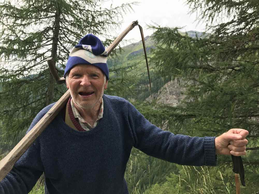 Oberhalb von der Moa Alm treffe ich den Osttiroler Almbauern Hubert. Mit Sense und Wanderstock ist er auf dem Weg zum Ausmähen der Panoramaaussicht.