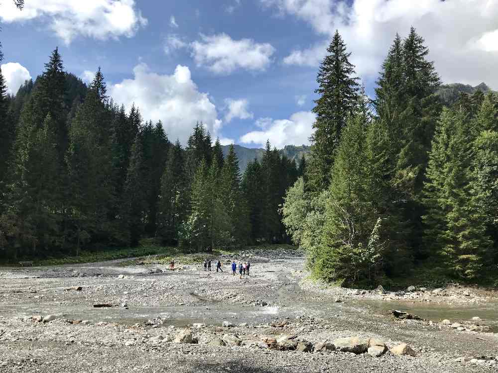 Der Bach im Derratal ist breit, rechts vom Ufer verläuft unser Wandersteig hinauf