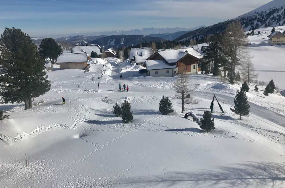  Vom Familienhotel geht es durch die verschneite Siedlung in Falkertsee zur Rodelbahn 