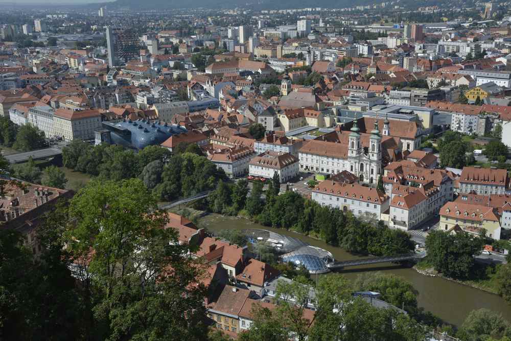 Auf dem Weg vom Glockenturm zum Uhrturm haben wir diese schöne Aussicht über Graz. Schön zu sehen: Rechts in der Mur die Murinsel und links oberhalb das Kunstmuseum mit der eigentümlichen Gebäudeform.