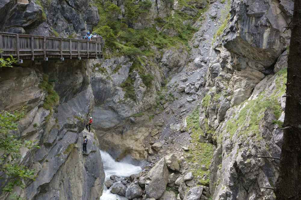 Oben verläuft der Wandersteig, unten sind die Kletterer auf dem Klettersteig an der Felswand