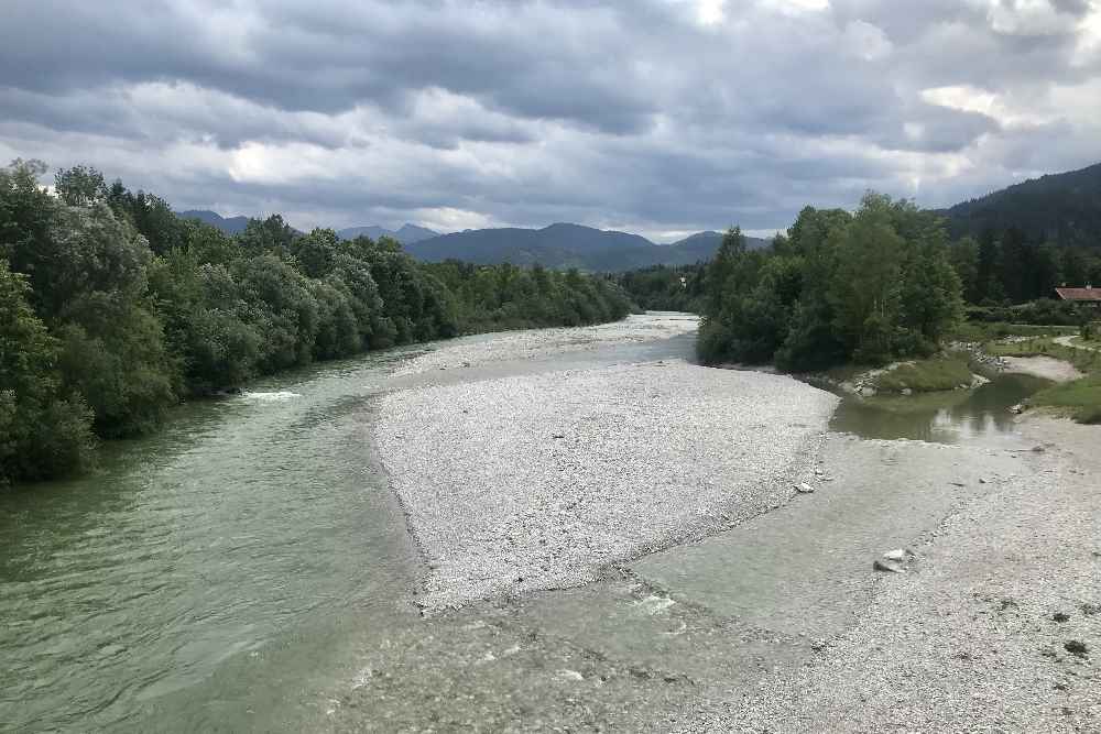 Der Blick auf die wilde Isar in Lenggries, hinten die Gipfel des Karwendel. Dort in den Bergen entspringt die Isar. 