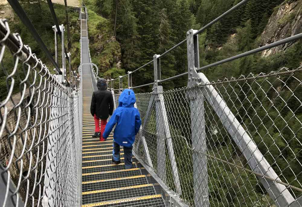 Die Hängebrücke ist steil - deshalb geht es über Stufen es auf der wackelnden Brücke hinunter 