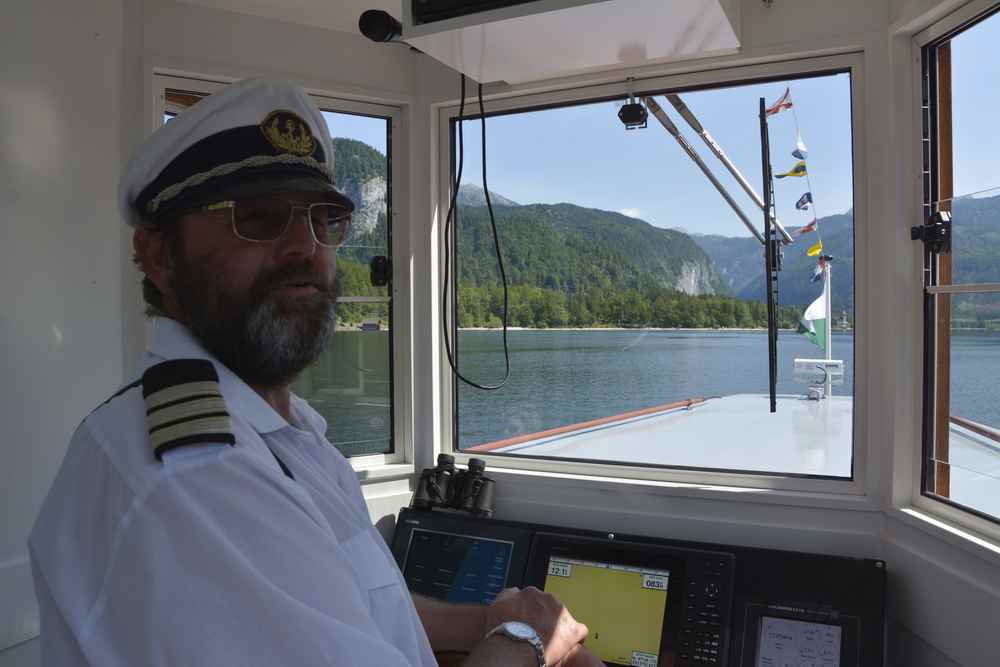 Unsere 3 Seen Tour im Salzkammergut beginnt: Der Kapitän auf dem Schiff liebt seinen Beruf und informiert über alles Wissenswerte 