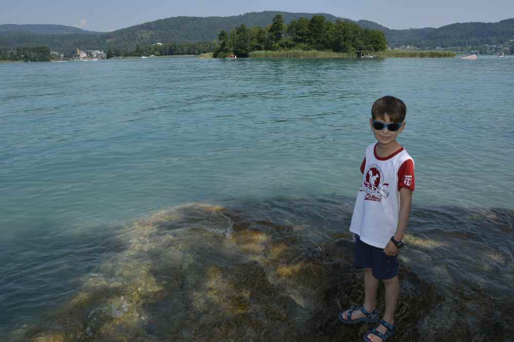 Die schöne Badestelle vor Maria Wörth mit dem kleinen Felsen im Wasser zum Spielen und Baden mit Kindern