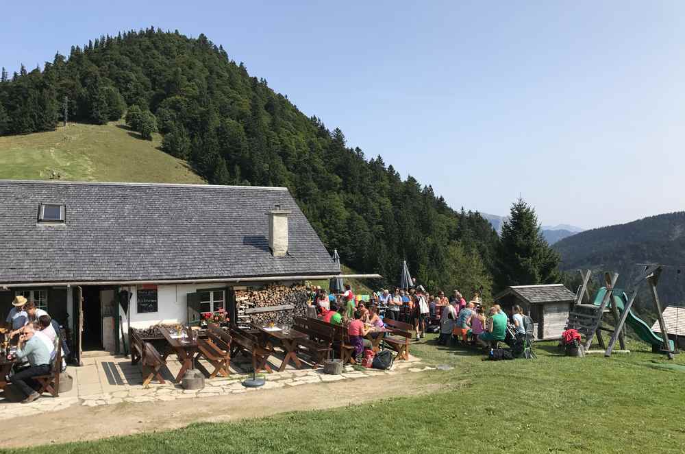 Eine der bewirtschafteten Hütten auf der Mittereggalm im Salzkammergut, hinten der Faistenauer Schafberg