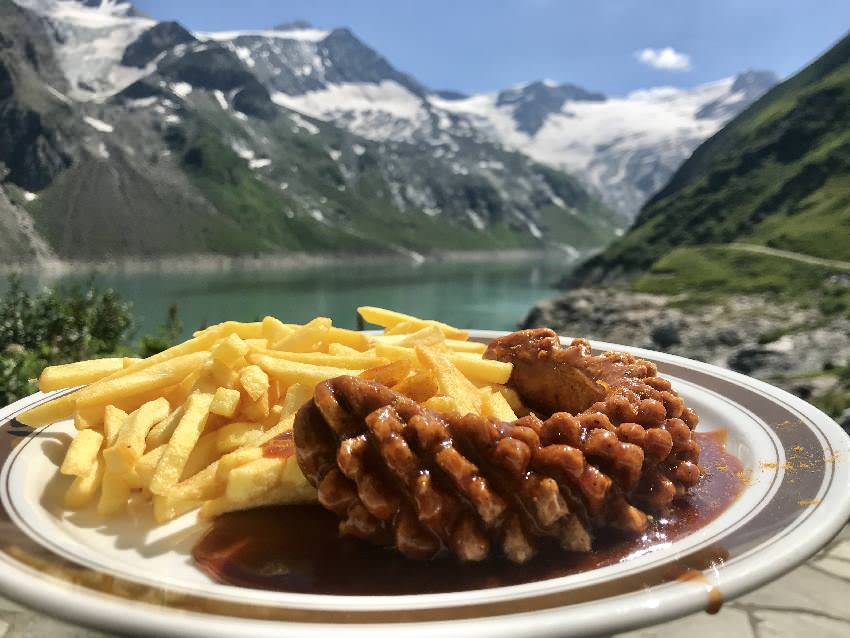 Im Mooserboden Restaurant holen wir uns eine Currywurst - gegessen wird mit diesem Seeblick!