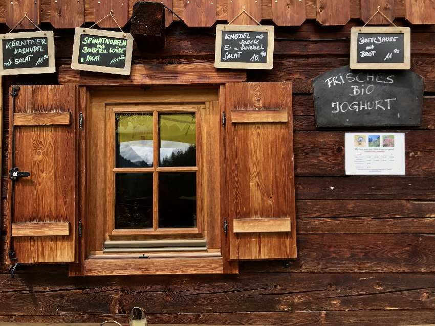 Sattelalm Speisekarte: Viele kleine Tafeln an der Holzwand der Almhütte