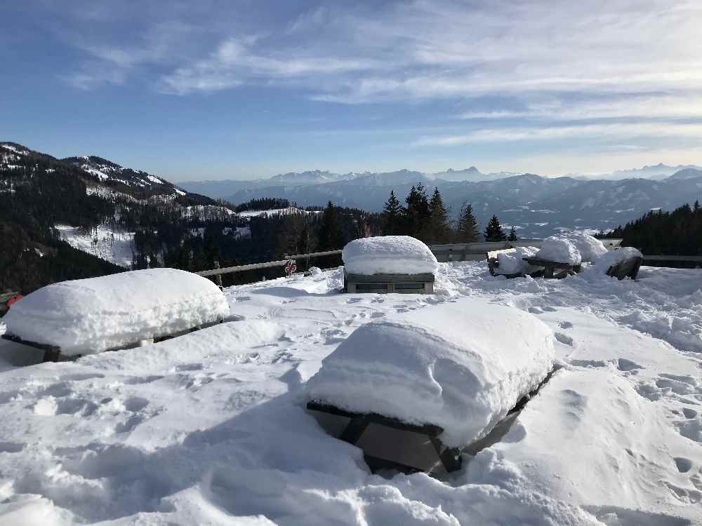 Die Bänke im Freien sind tief verschneit. 