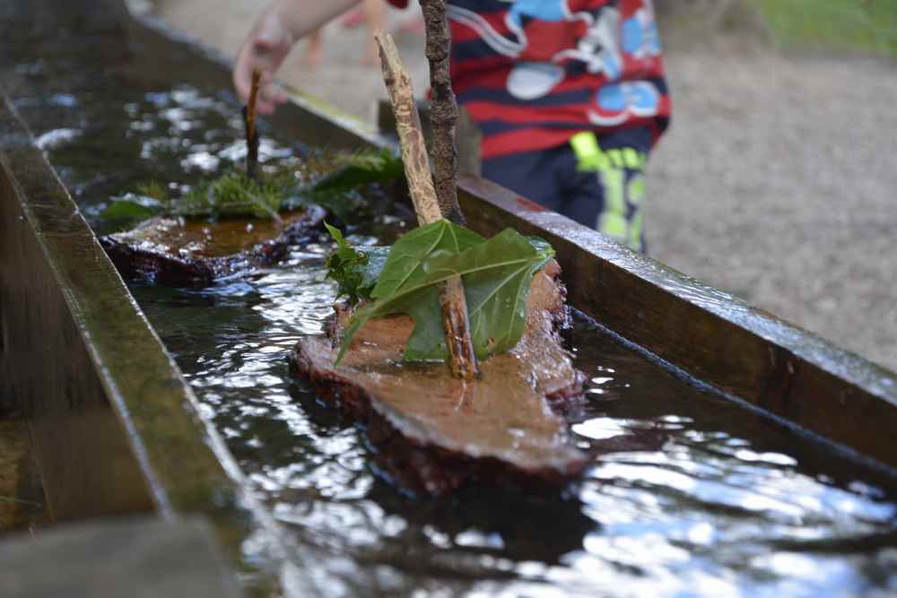 Mit der Baumrinde basteln Kinder auf der Bürgeralpe kleine Boote