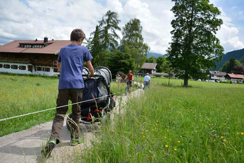 Auf einem Weg zwischen den Wiesen wandern wir mit dem Kinderwagen nach Abwinkl