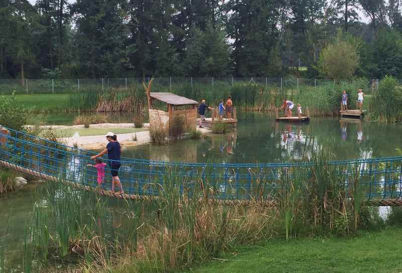 Erlebnispark Wasser Fisch Natur am Murner See: Spielplatz mit Floß und Hängebrücke über dem Wasser