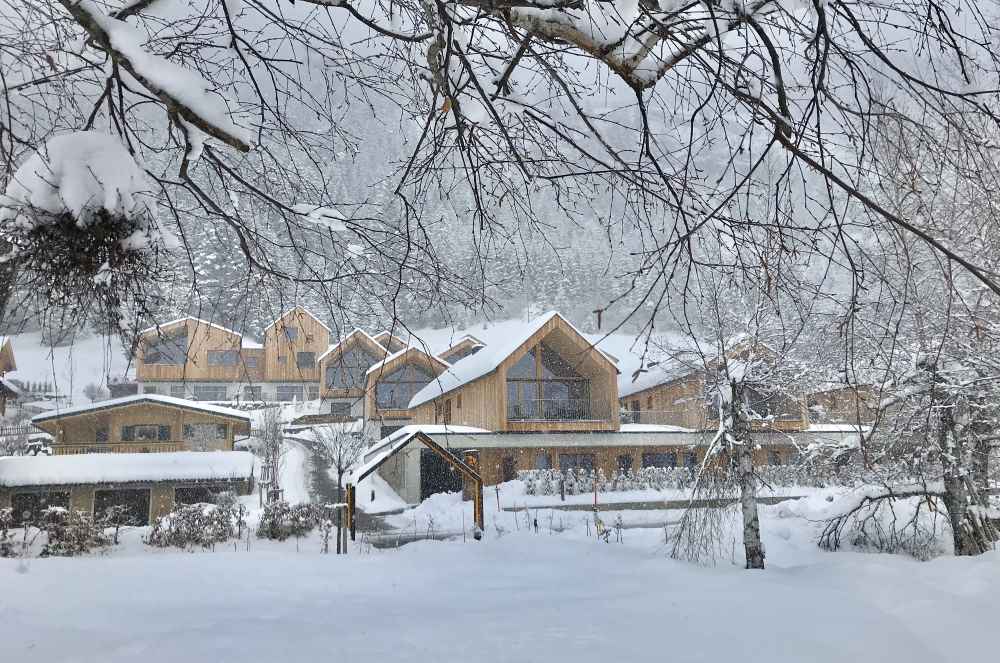 Von den Holzhütten und Chalets des Regitnig wandern wir durch den Schnee zur Rodelbahn in Weissensee 