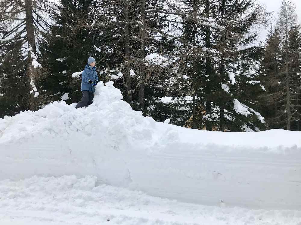 Soviel Schnee! Der Kleine hat seinen Spaß beim Klettern auf den großen Schneebergen 