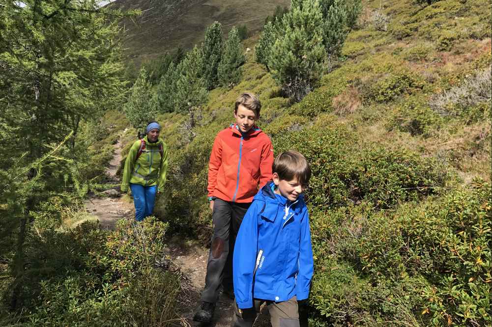 Meransen Wandern mit Kindern: In der Sonne auf dem Weg zur Bergbahn, für die Fahrt ins Tal nach Meransen