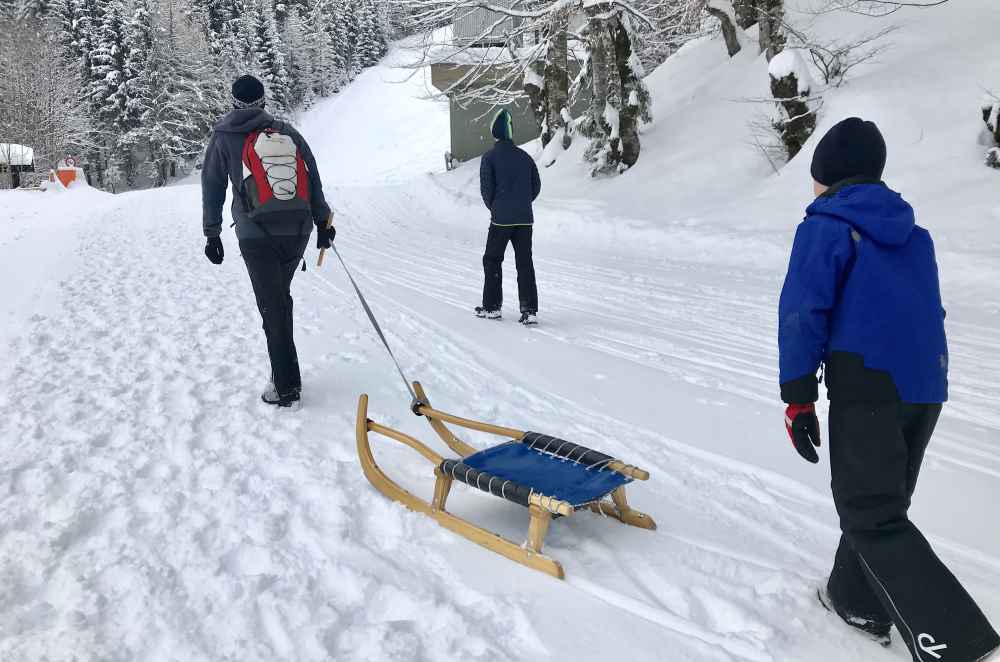 Weissensee rodeln - Wir lassen uns vom Neuschnee nicht abhalten und spuren auf der Rodelbahn hinauf unseren Weg