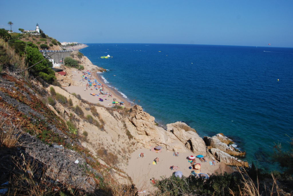 Calella Spanien - rechts der Strand, links auf der Anhöhe der Leuchtturm