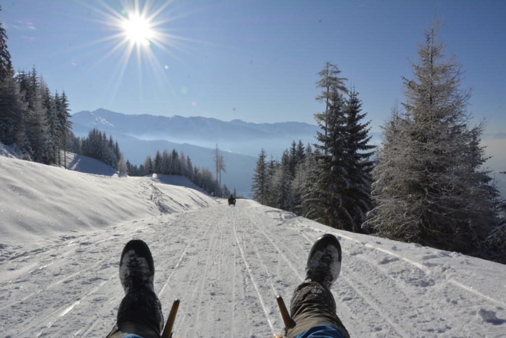 Eine Rodelbahn Tirol geniessen - mit einer kilometerlangen Abfahrt der Sonne entgegen