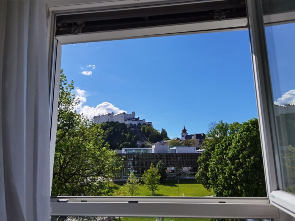 Fenster auf und rausschauen: Unser Zimmer-Ausblick im Familienhotel Salzburg auf die Festung Hohensalzberg