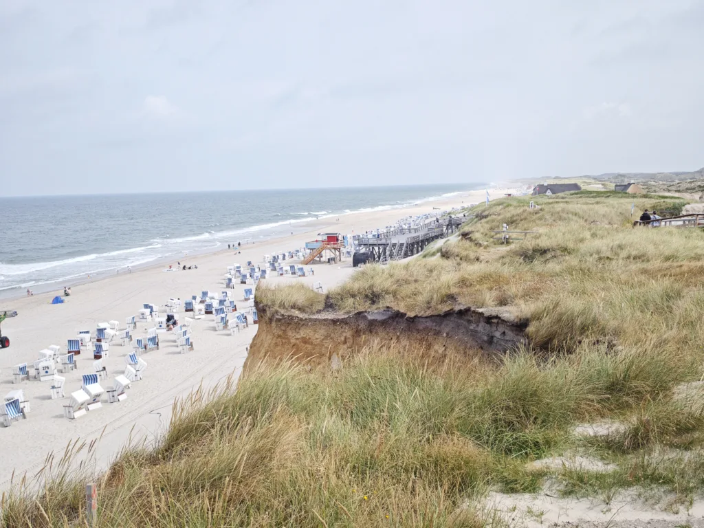 Die Steilküste des Roten Kliffs fällt senkrecht direkt zum Badestrand ab