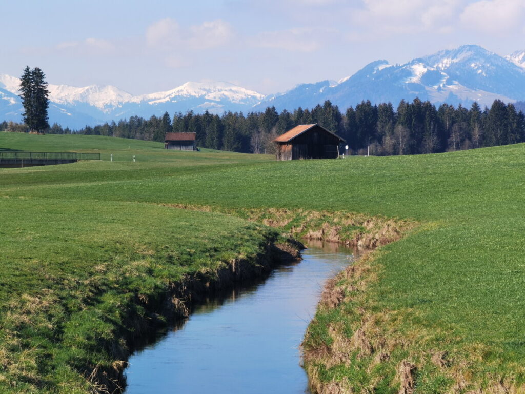 Auf dem Weg zum Geratser Wasserfall - die Wanderung führt in der Wiesenlandschaft, umgeben von Bergen