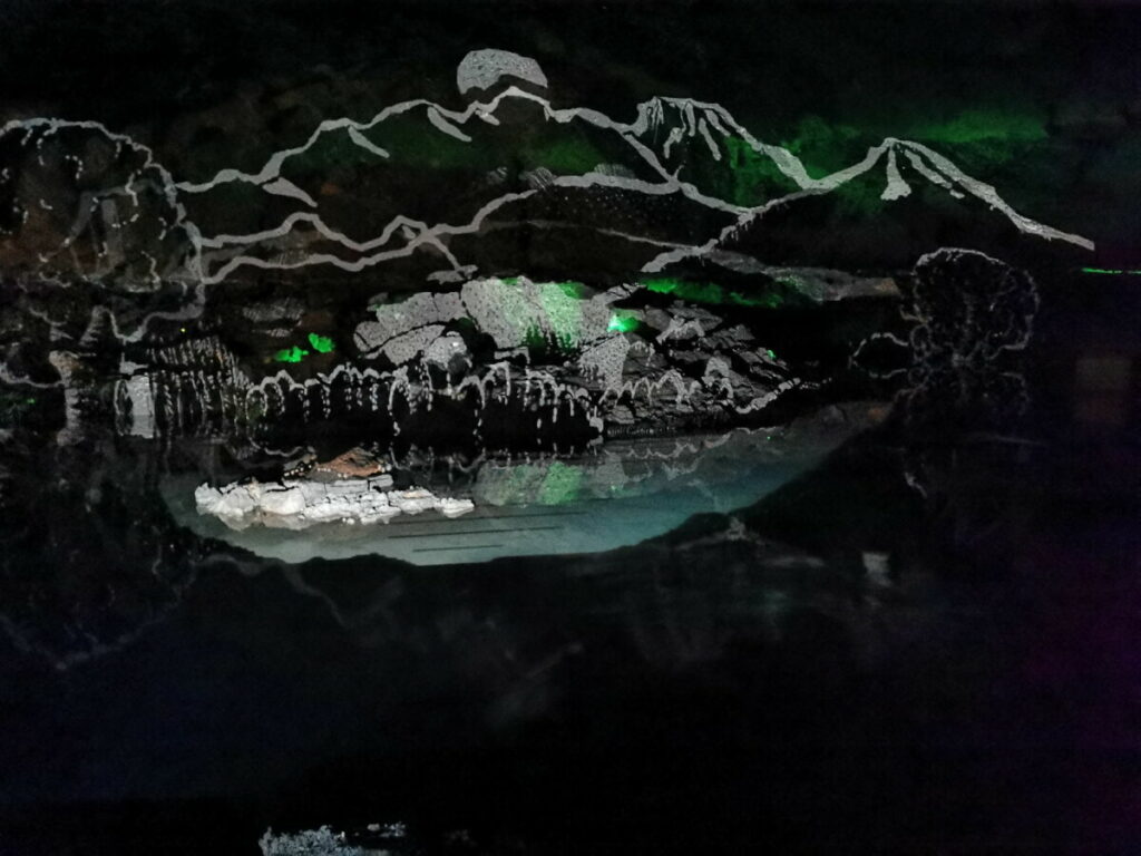 Lichtershow in den Salzwelten Hallstatt - die Figuren spiegeln sich im Salzsee