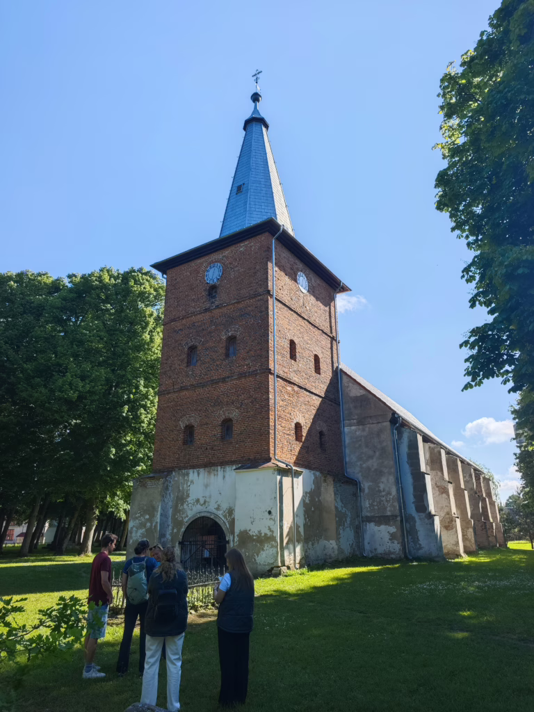 Unser Ortsrundgang in Rusnė startet an der Kirche - dann geht es am Fluss entlang