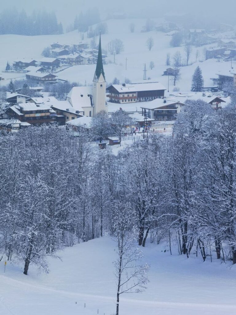 Der Blick zurück auf das verschneite Ortszentrum Niederau in der Wildschönau 