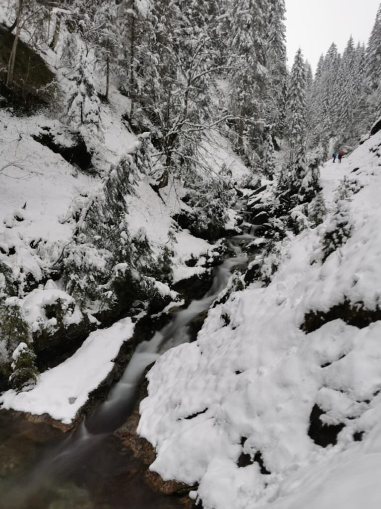 Winterwandern Kleinwalsertal Bergunt - Wasserfall und rechts klein die Leute am Wanderweg